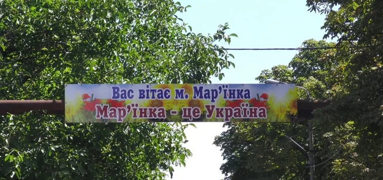 Дорожній банер, на якому написано: "Вас вітає Мар’їнка. Мар’їнка - це Україна"